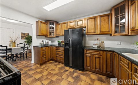 A kitchen with wooden cabinets and black appliances.