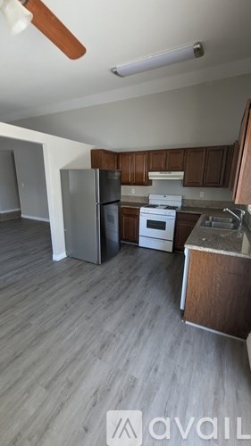 A kitchen with a white stove and a white refrigerator.