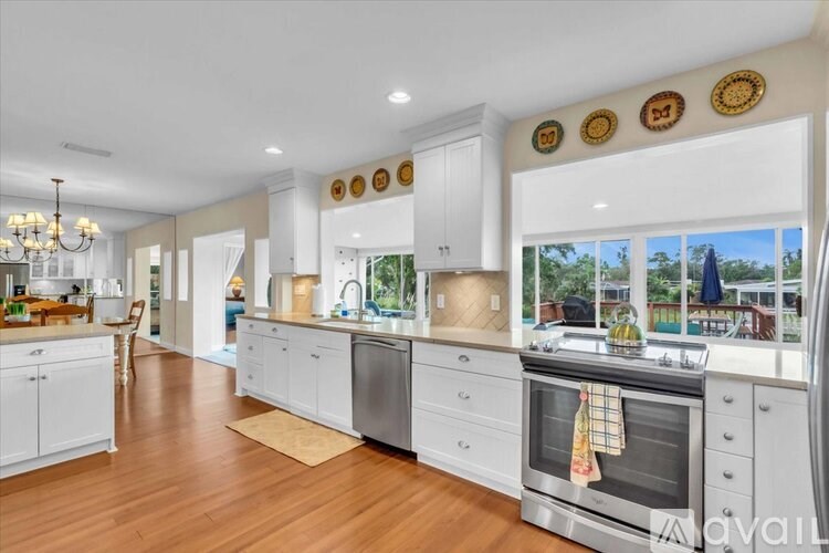 A modern kitchen with white cabinets and stainless steel appliances.