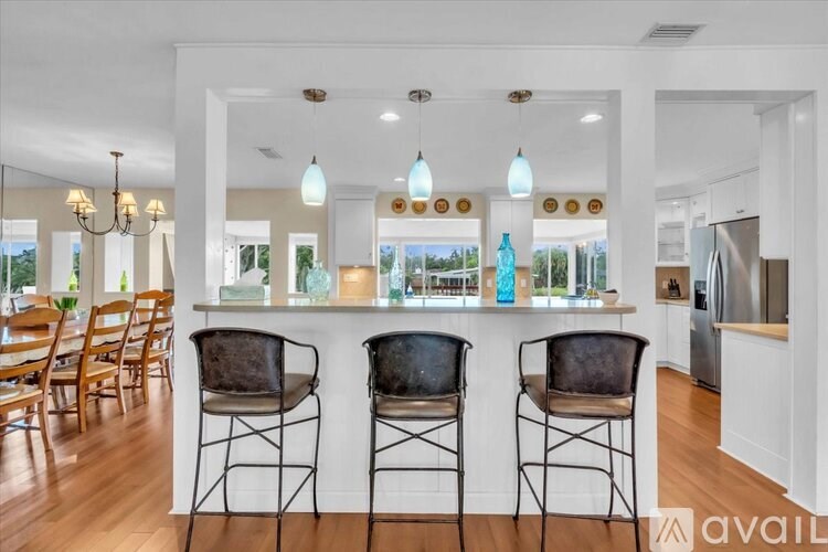 A kitchen with a bar area and chairs.