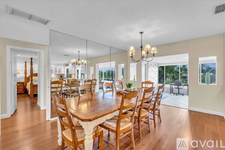A dining room with a large wooden table and chairs.