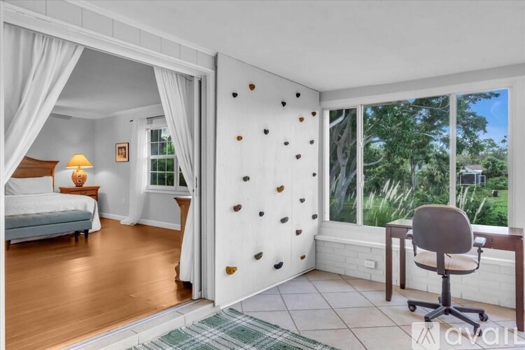 A room with a climbing wall and a desk.
