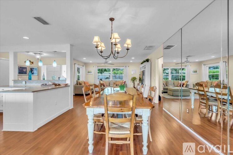 A well-lit dining room with a wooden table and chairs.