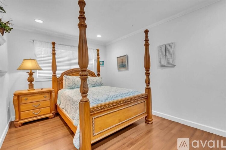 A bedroom with a large bed and a wooden dresser.