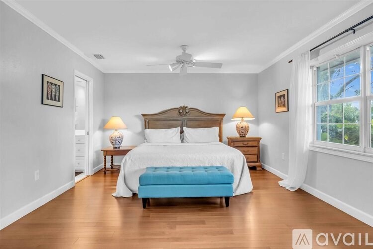 A bedroom with a large bed and a ceiling fan.