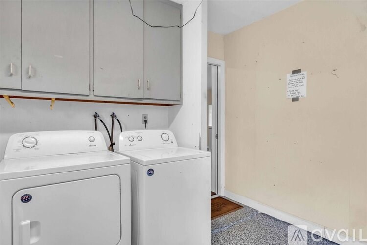 Two white HP washing machines in a laundry room.