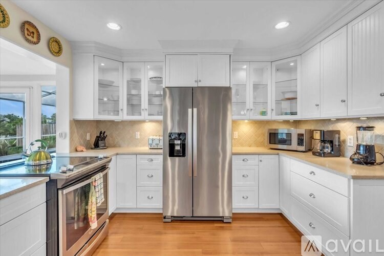A pool enclosed by a white frame with a glass ceiling.