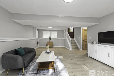 A living room with a grey sofa and a white coffee table.