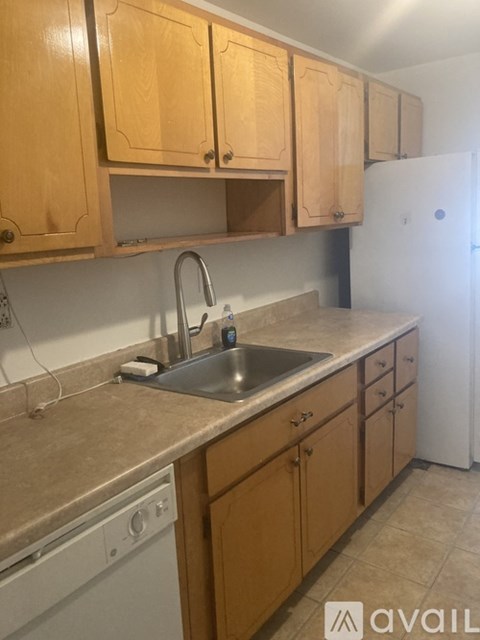 A kitchen with wooden cabinets and a white dishwasher.