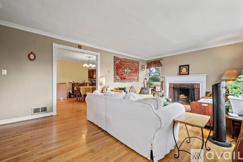 A living room with a white couch and a fireplace.