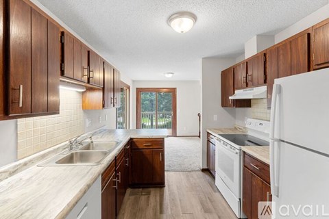 A kitchen with wooden cabinets and white appliances.