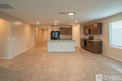 A spacious kitchen and living room with a television and a microwave.