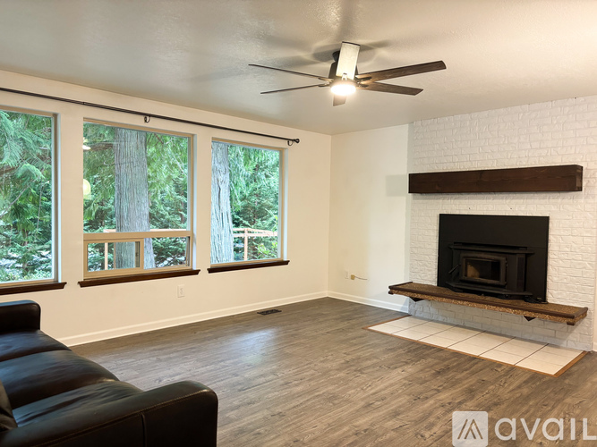 A living room with a fireplace and a ceiling fan.