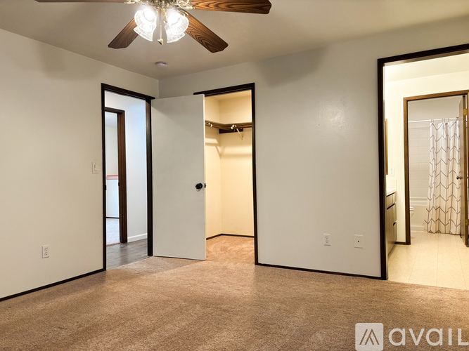 A spacious room with a ceiling fan and a carpeted floor.