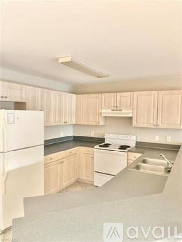 A kitchen with white appliances and cabinets.