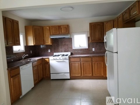 A kitchen with wooden cabinets and white appliances.