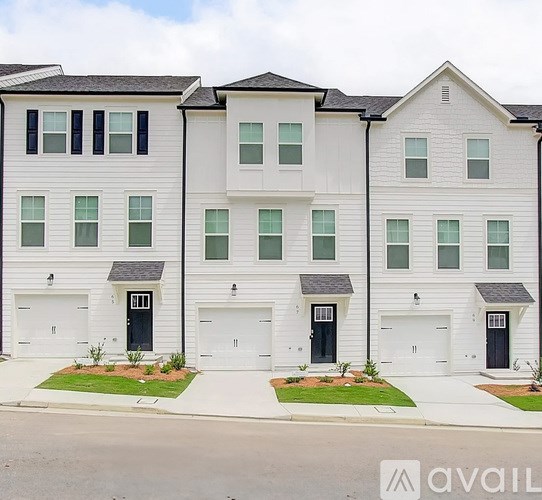 A row of white townhouses with black doors and windows.