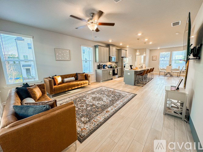 A living room with a brown couch and a rug.