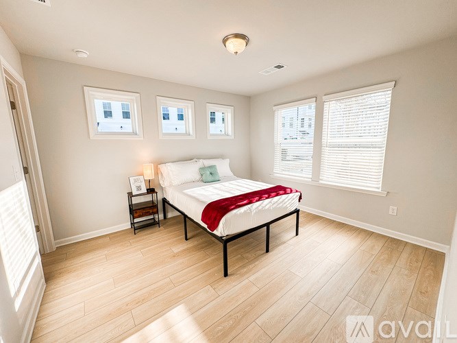 A bedroom with a bed, nightstand, and window.