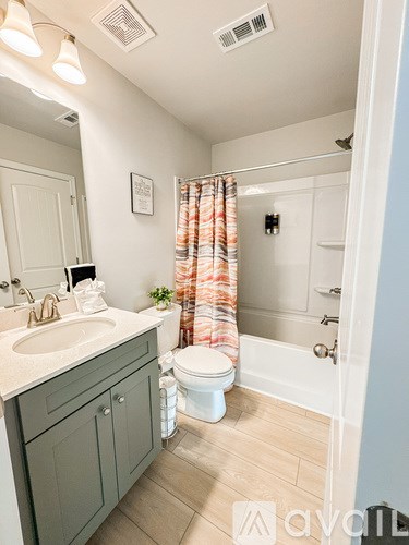 A bathroom with a toilet, sink, and shower.