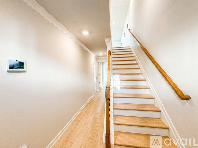 A staircase with wooden steps and a light brown handrail.
