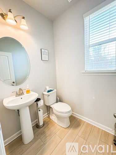 A bathroom with a sink, toilet, and mirror.