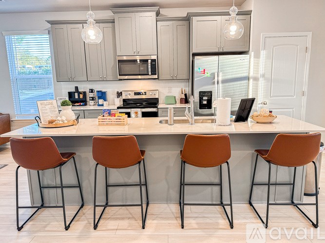A kitchen with a bar and chairs.