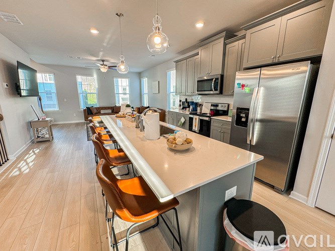 A kitchen with a long counter and stainless steel appliances.