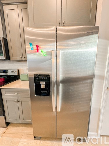 A stainless steel refrigerator with a water and ice maker dispenser in the middle.