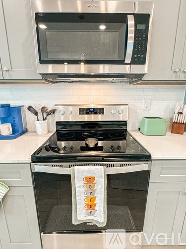 A modern kitchen with a stove top oven and microwave above it.