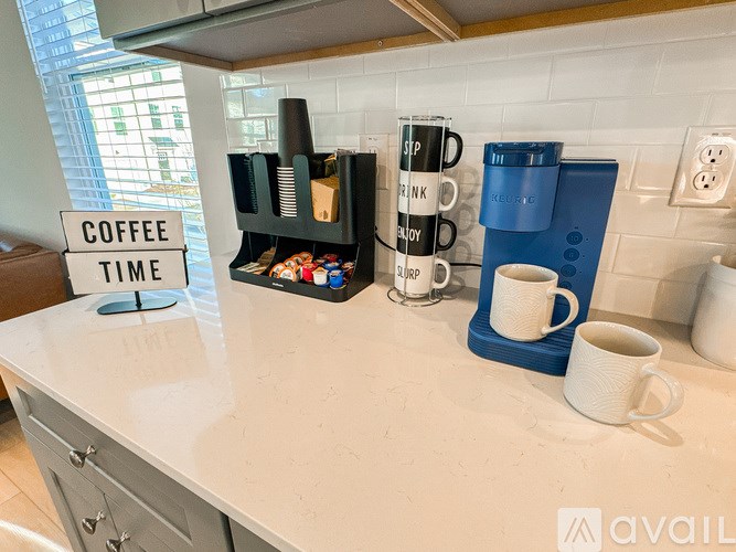 A coffee time sign is on a table with coffee cups and a coffee maker.