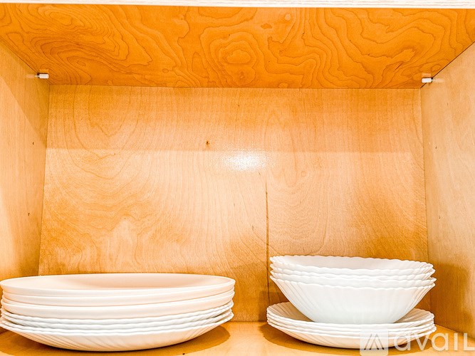 A stack of white plates sits on a shelf.