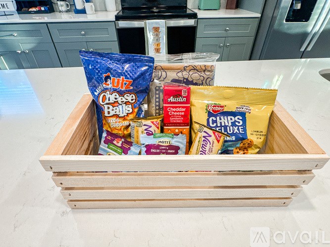 A wooden crate filled with various bags of chips.