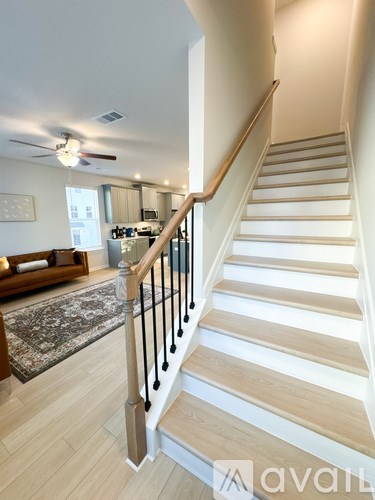 A staircase with a black railing and wooden steps.