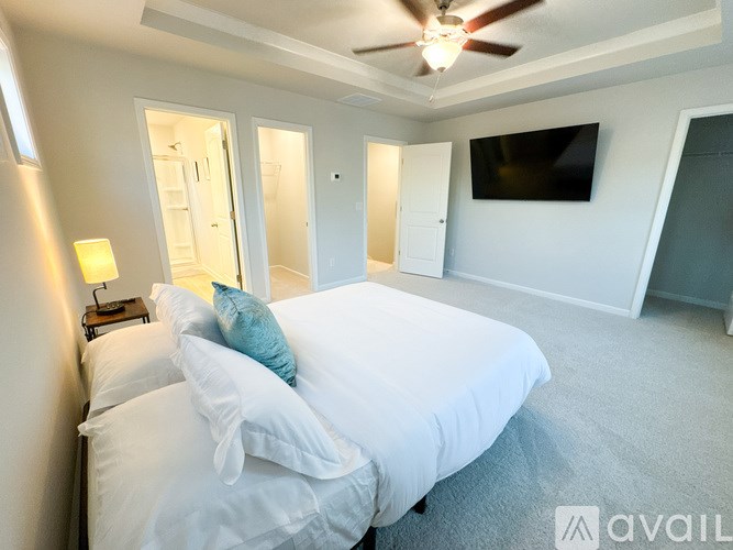 A bedroom with a large bed and a flat screen TV mounted on the wall.