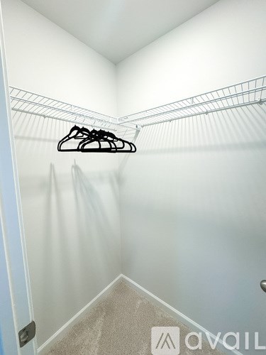 A white closet with a hanger on the shelf.