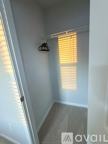 A room with a white door and a window with blinds.