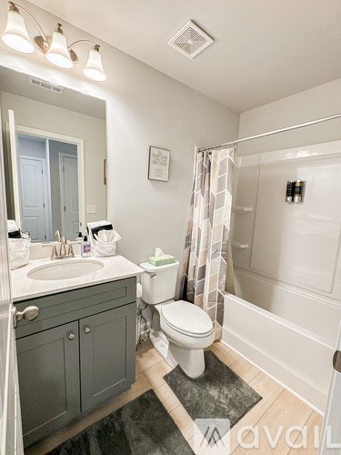 A bathroom with a toilet, sink, and shower.