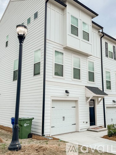 A white house with a black lamp post in front.