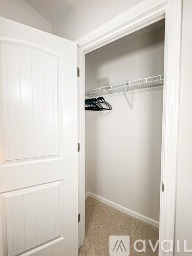 A white closet with a shelf and a hanger.