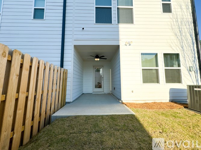 A white house with a wooden fence in front.