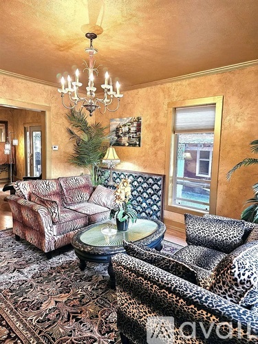 A living room with a leopard print chair and a chandelier.