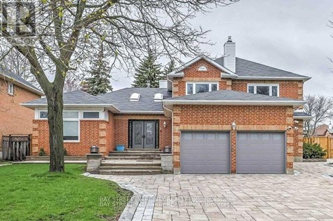 A brick house with a grey roof and a grey garage door.