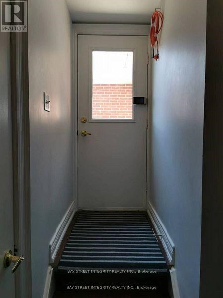 A hallway with a door and a sign that says Bay Street Integrity Realty Inc. Brokerage.