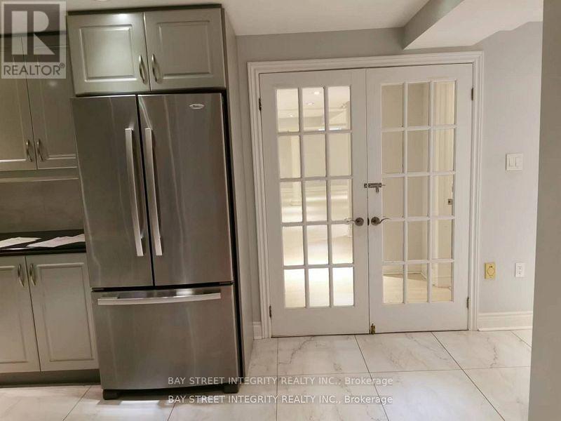 A kitchen with a stainless steel refrigerator and a white door.