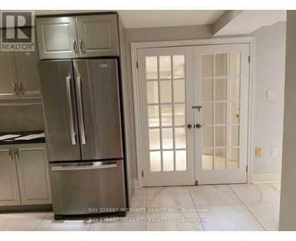 A kitchen with a stainless steel refrigerator and a white door.