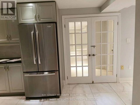 A kitchen with a stainless steel refrigerator and a white door.