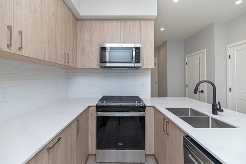 A modern kitchen with a stainless steel oven and microwave.