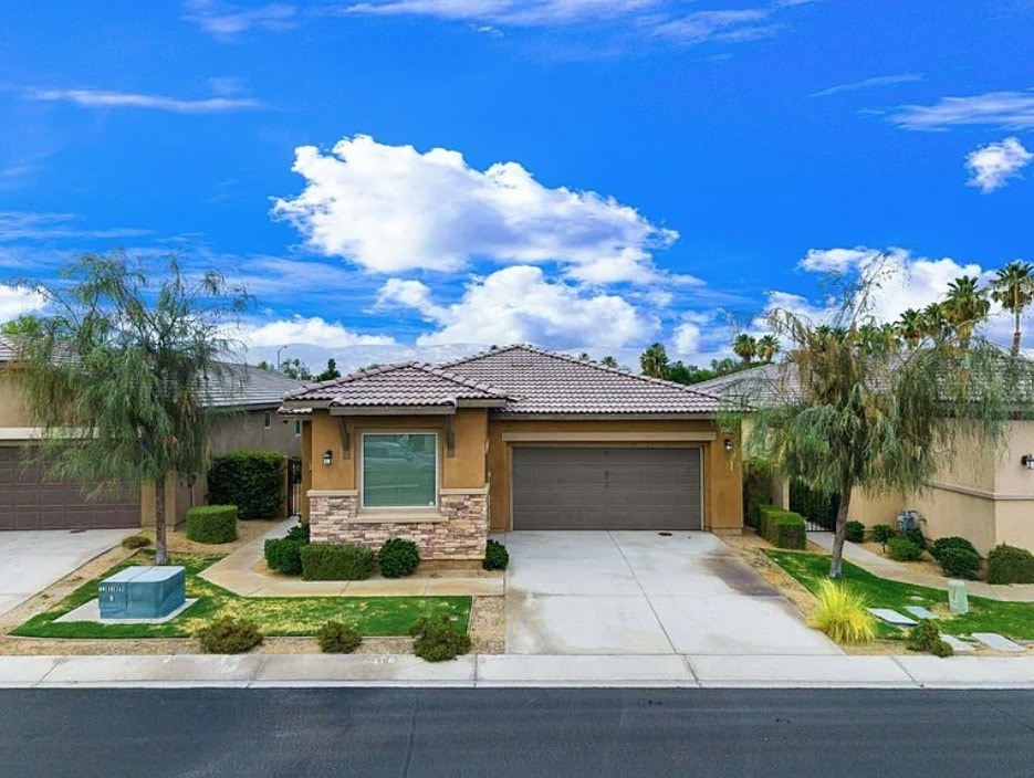 A house with a brown roof and a grey garage door.