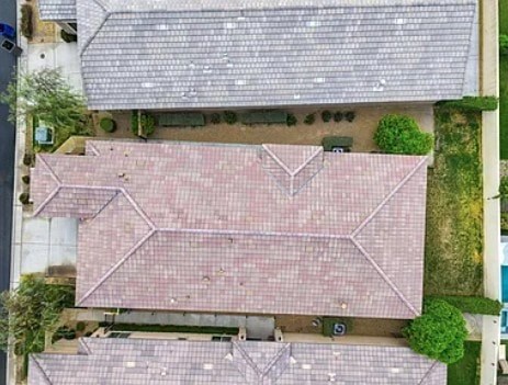 A roof with a red tile and a grey tile.